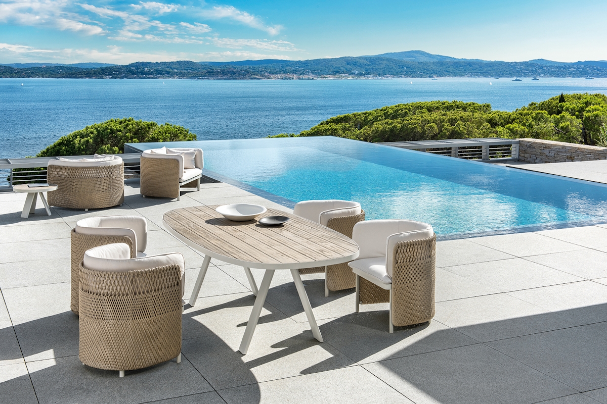 Ethimo Esedra outdoor dining and living range against backdrop of swimming pool and scenic ocean views