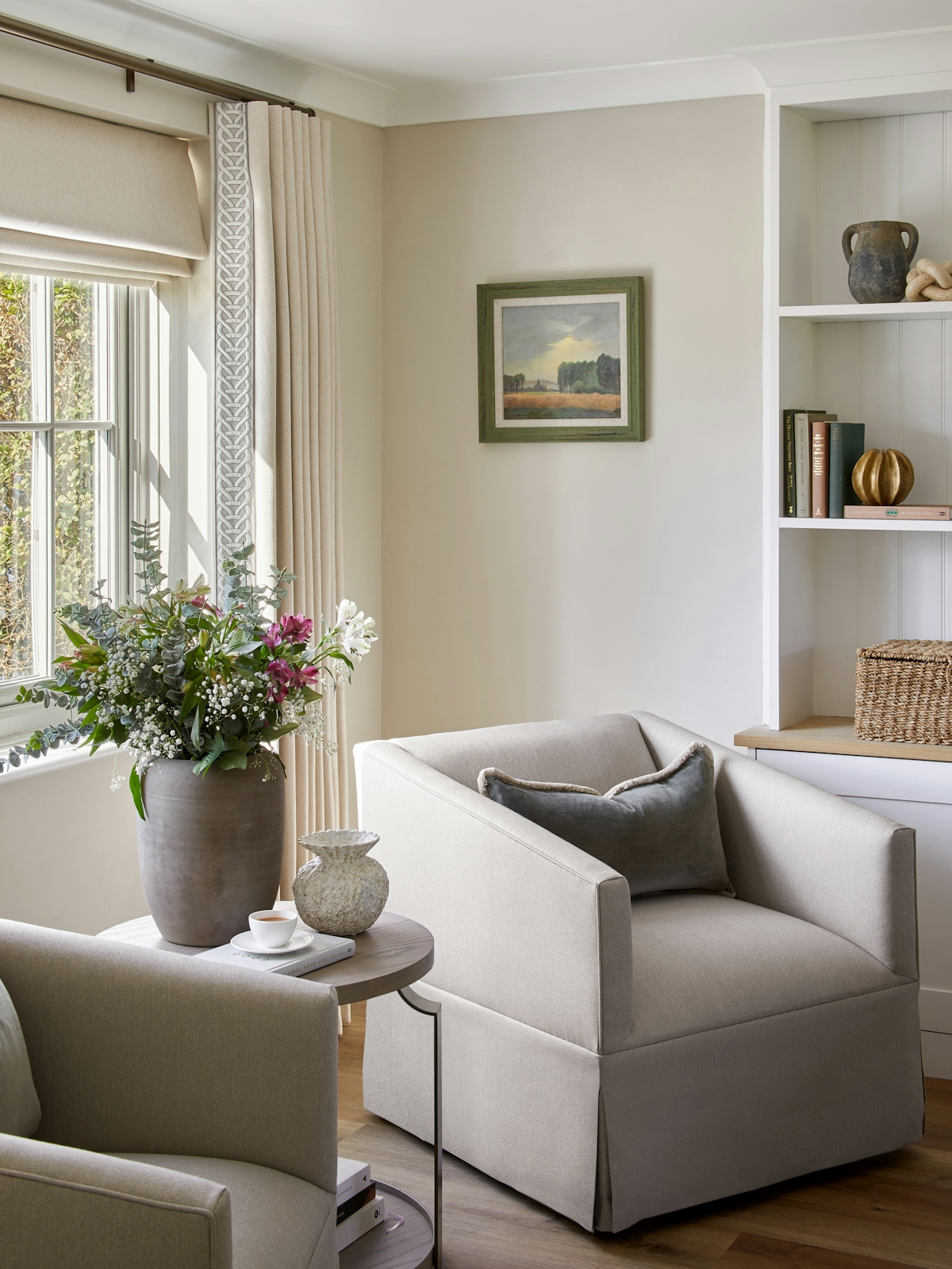 Modern country style linen Keswick Swivel Armchair by LuxDeco and Dakota side table by Loom, fresh flowers in rustic vase